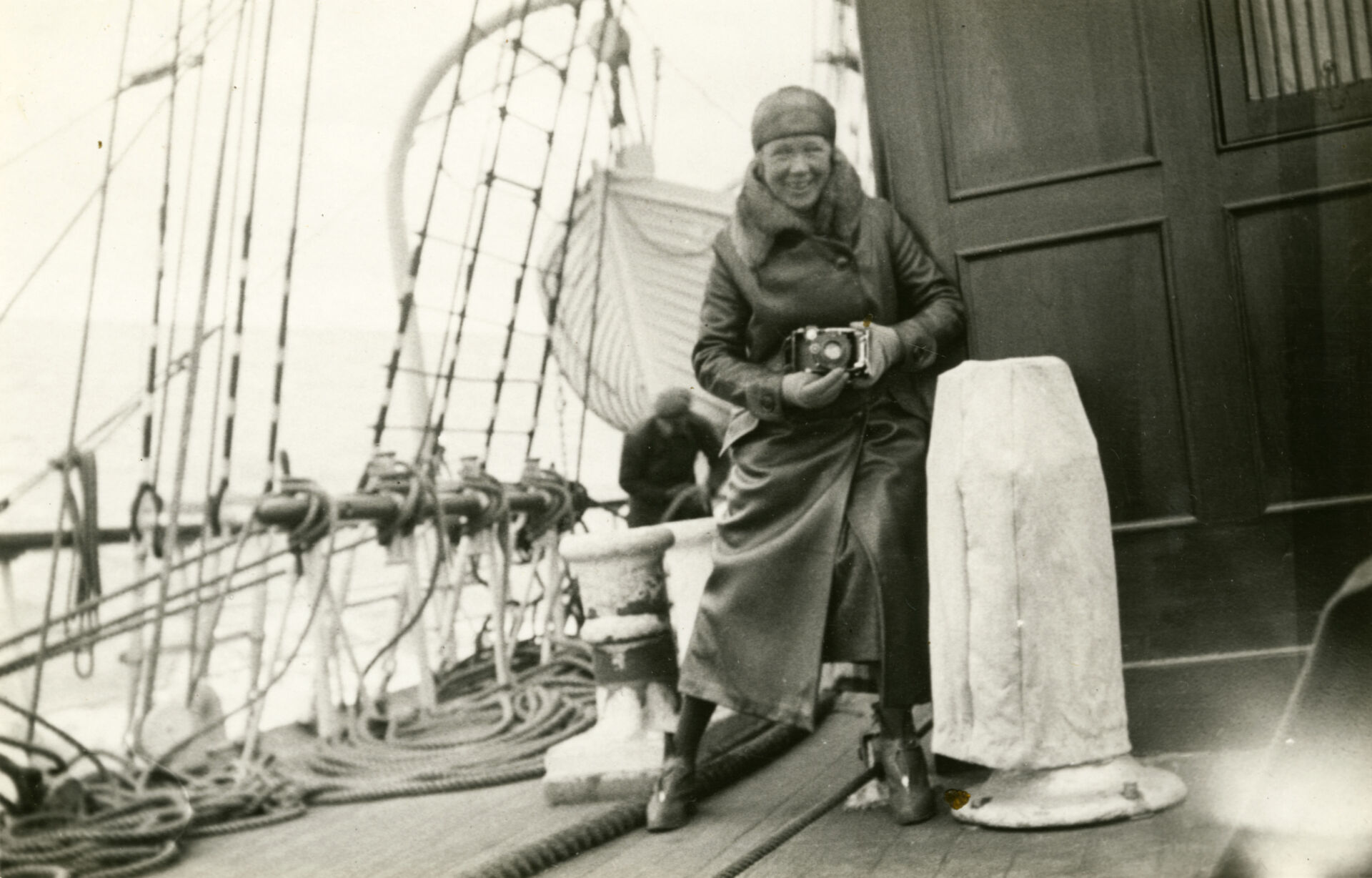 På bilden står Signe med sin kamera ombord segelfartyget L'Avenir. Resan gick från Mariehamn på Åland till Köpenhamn mellan den 13 och 23 september 1932.